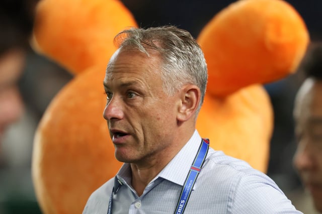 Cubs president of baseball operations Jed Hoyer talks with colleagues before an exhibition game against the Yomiuri Giants at the Tokyo Dome on March 16, 2025. (John J. Kim/Chicago Tribune)