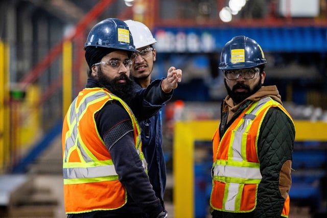 Workers discuss their job at Steelcon, a structural steel design and fabrication company, in St. Catharines, Ontario, Canada, January 31, 2025. REUTERS/Carlos Osorio/File photo