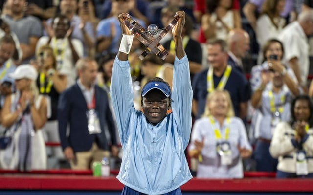 Victoria Mboko of Canada hoists the trophy following her win over Naomi Osaka of Japan during finals tennis action at the National Bank Open in Montreal, Thursday, Aug. 7, 2025. 