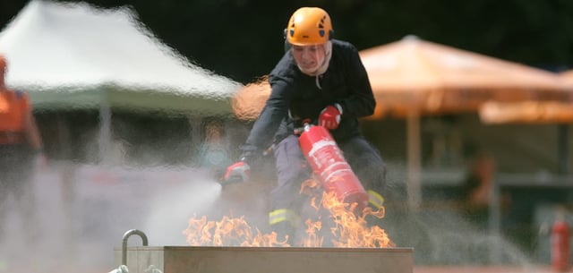 Eine Feuerwehrsportlerin trainiert im Hafenstadion in Torgau das Löschen eines Flüssigkeitsbrandes