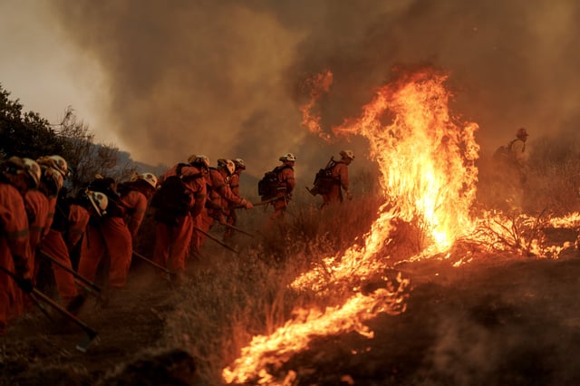 Firefighters battle flames from the Canyon Fire on August 7, 2025 in Castaic, California.