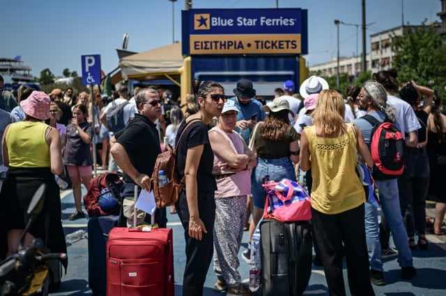 Des passagers attendent un ferry dans le port du Pirée, près d'Athènes, le 8 août 2025