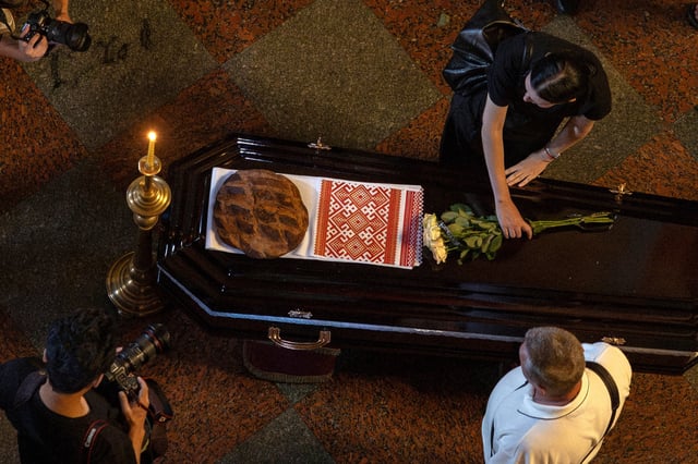 A woman lays flowers on the coffin of Ukrainian journalist Viktoria Roshchyna, who died in Russian captivity, at St. Michael's Golden-Domed Cathedral, amid Russia's attack on Ukraine, in Kyiv, Ukraine August 8, 2025. REUTERS/Thomas Peter