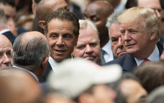 New York Governor Andrew Cuomo (C) speaks with former New York City mayor Rudolph Giuliani (L) as Republican presidential candidate Donald Trump, right looks on during the 15th Anniversary of September 11 at the 9/11 Memorial and Museum, on September 11, 2016, in New York.