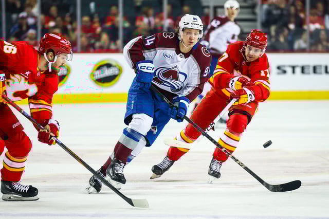 Mar 14, 2025; Calgary, Alberta, CAN; Colorado Avalanche left wing Joel Kiviranta (94) controls the puck against against Calgary Flames center Yegor Sharangovich (17) during the first period at Scotiabank Saddledome. Mandatory Credit: Sergei Belski-Imagn Images/ File Photo