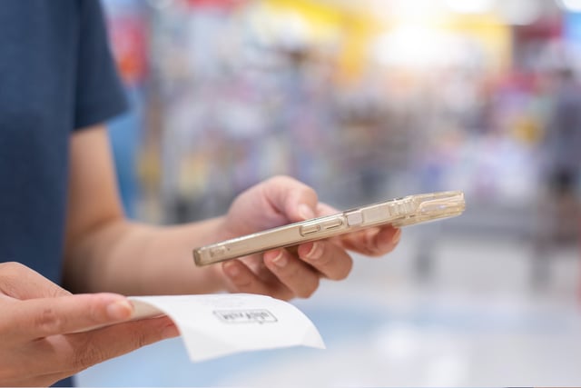 Woman using smart phone scanning qr code on the bill to pay online,Accounting