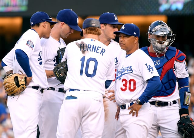 Dave Roberts #30 of the Los Angeles Dodgers visits pitcher Alex Wood #57 during the fifth inning against the New York Mets at Dodger Stadium on September 3, 2018 in Los Angeles.