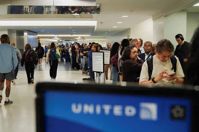 Travelers wait in line for their delayed luggage after United Airlines grounded flights due to a tech outage at Newark Liberty International Airport in Newark, New Jersey, U.S., August 6, 2025. REUTERS/Ryan Murphy/File Photo