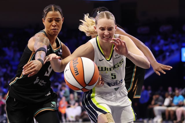 Paige Bueckers #5 of the Dallas Wings reaches for a loose ball against Natasha Cloud #9 of the New York Liberty during a game against the New York Liberty at College Park Center on July 28, 2025 in Arlington, Texas.