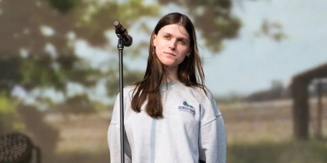 Ethel Cain onstage, wearing a sweatshirt.