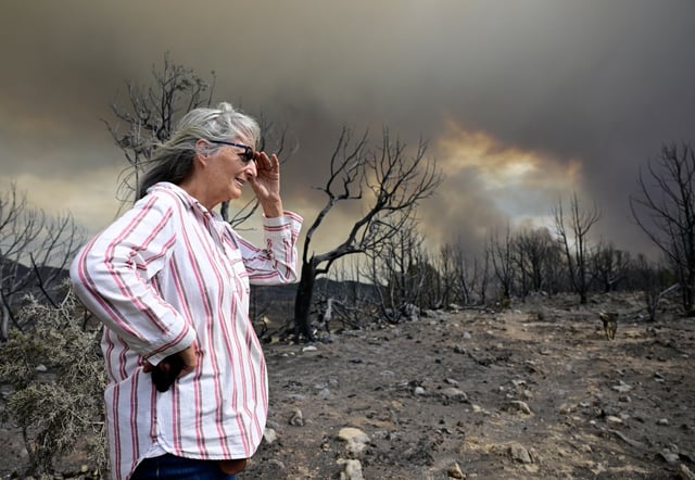 Kathleen Kelley at her ranch as smoke billows from the Lee fire in Rio Blanco County just outside of Meeker, Colorado, on Friday, Aug. 8, 2025. Kelley&#39;s home was got some damage but did not burn down. The land around the home also was scorched. (Photo by Andy Cross/The Denver Post)