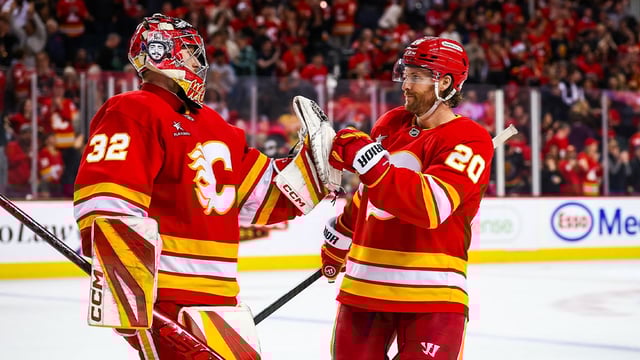 Apr 15, 2025; Calgary, Alberta, CAN; Calgary Flames goaltender Dustin Wolf (32) celebrate win with teammates after defeating Vegas Golden Knights at Scotiabank Saddledome. Mandatory Credit: Sergei Belski-Imagn Images
