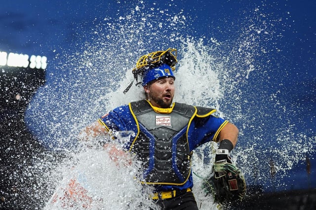 Cal Raleigh, receptor de los Marineros de Seattle, reacciona luego de ser bañado por su compañero Víctor Robles para celebrar su cuadrangular de tres carreras después de una victoria en el juego de béisbol de Grandes Ligas frente a los Rays de Tampa Bay el viernes 8 de agosto de 2025, en Seattle. (AP Foto/Lindsey Wasson)