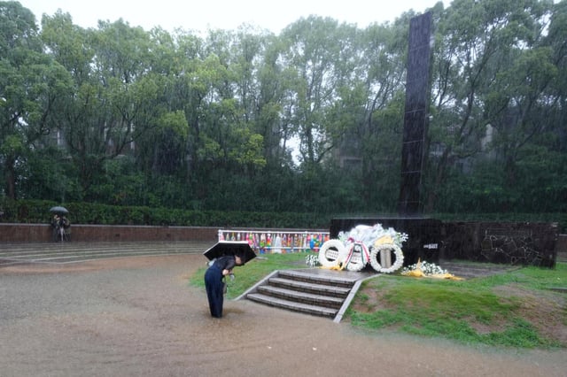 Una persona se inclina para rezar bajo la lluvia, en el Parque de la Paz antes de una ceremonia pública para conmemorar el 80 aniversario del día en que se arrojó una bomba nuclear sobre la ciudad, en Nagasaki, Japón, el 9 de agosto de 2025.(AP Foto/Eugene Hoshiko)