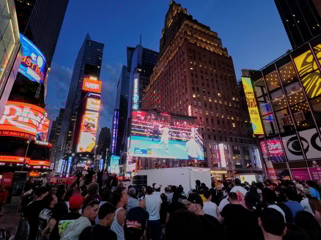 People gather in Times Square to watch a boxing match Friday, May 2, 2025, in New York. (AP Photo/Frank Franklin II)