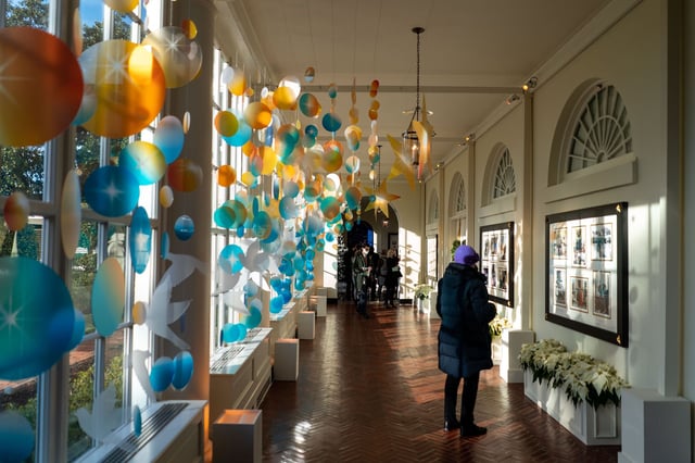 In this December 2021 photo, people make their way through the East Colonnade of the East Wing of the White House in Washington, DC.