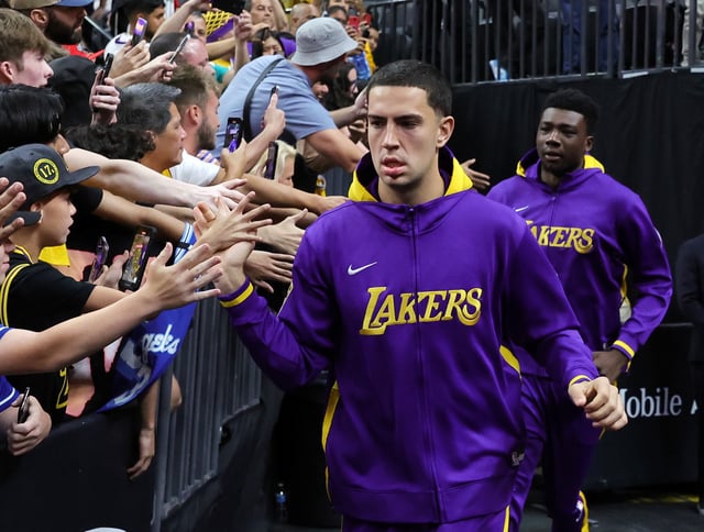 Cole Swider (L) #20 and Thomas Bryant #31 of the Los Angeles Lakers are greeted by fans as they take the court for warmups before a preseason game against the Minnesota Timberwolves at T-Mobile Arena on October 06, 2022 in Las Vegas, Nevada.
