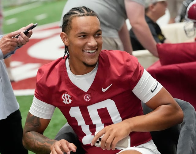 Aug. 4, 2025; Tuscaloosa, AL, USA; Alabama Crimson Tide players and coaches participate in a media day with reporters and fans at the Hank Crisp Indoor Practice Facility. Quarterback Austin Mack smiles as he is surrounded by fans.