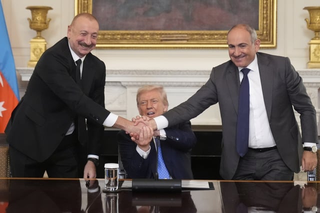 President Donald Trump, center, shakes hands with Armenian Prime Minister Nikol Pashinyan, right, and Azerbaijan President Ilham Aliyev during a trilateral signing ceremony in the State Dining Room of the White House, Friday, Aug. 8, 2025, in Washington. (AP Photo/Mark Schiefelbein)
