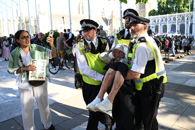 La policía arrestó a un manifestante de 89 años durante una manifestación de apoyo al grupo proscrito Acción Palestina, en la Plaza del Parlamento, en el centro de Londres. (Photo by Chris J Ratcliffe / AFP)
