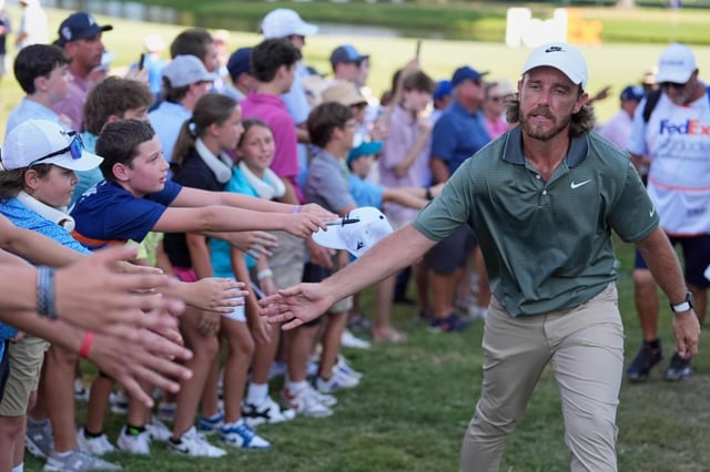 El inglés Tommy Fleetwood festeja con los aficionados tras ssalir del hoyo 18 en el St. Jude Championship, el sábado 9 de agosto de 2025, en Memphis (AP Foto/George Walker IV)