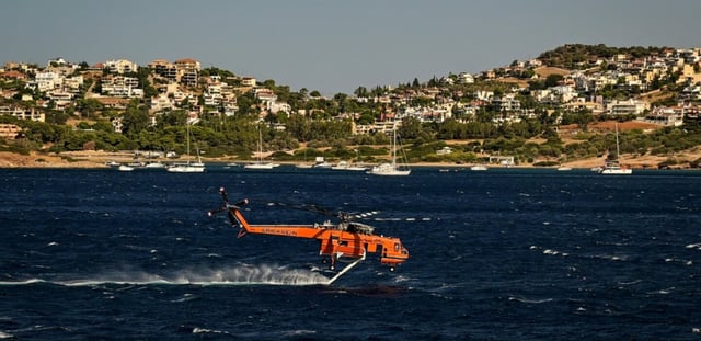 Un hélicoptère de lutte contre les incendies Erickson se remplit d'eau dans la mer lors d'un incendie de forêt à Palaia Fokaia, à environ 43 km au sud d'Athènes, le 9 août 2025.