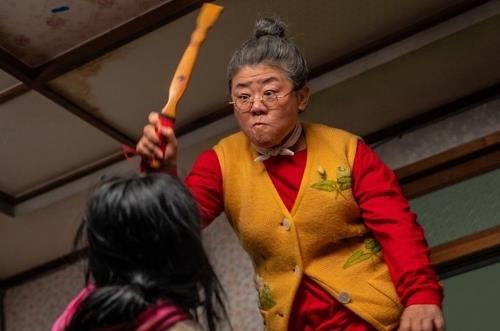 Bam-soon brandishes her back scratcher at her zombie granddaughter, Soo-ah, in this still from "My Daughter is a Zombie," provided by NEW. (PHOTO NOT FOR SALE) (Yonhap)