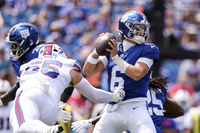 Michael Hoecht #55 of the Buffalo Bills attempts to tackle Jaxson Dart #6 of the New York Giants during the first quarter of an NFL Preseason 2025 game between New York Giants and Buffalo Bills at Highmark Stadium on August 09, 2025 in Orchard Park, New York.