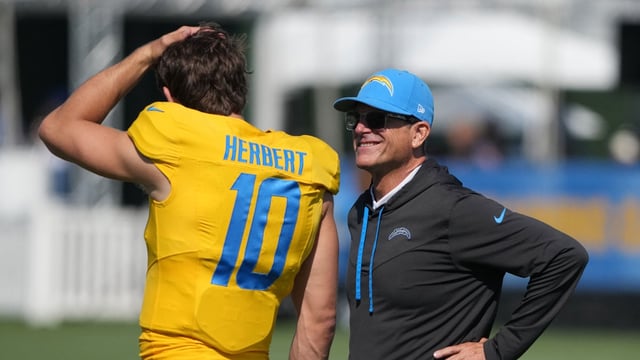 Aug 7, 2025; El Segundo, CA, USA;Los Angeles Chargers coach Jim Harbaugh (left) talks with quarterback Justin Herbert (10) during training camp at The Bolt. Mandatory Credit: Kirby Lee-Imagn Images