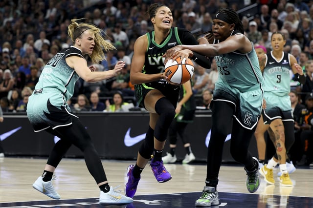 Napheesa Collier #24 of the Minnesota Lynx powers through defense by Sabrina Ionescu #20 and Jonquel Jones #35 of the New York Liberty in the first quarter at Target Center on July 30, 2025 in Minneapolis, Minnesota.