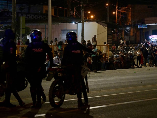 Police officers stand guard outside the Regional 8 prison complex after an "internal revolt" at the Guayas 4 block, in Guayaquil, Ecuador, on March 27, 2024. At least one dead and four injured left Wednesday's riot in a prison in the port of Guayaquil, from which the feared leader of one of the largest criminal gangs in Ecuador escaped in January, the Deputy Minister of Security, Lyonel Calderon, reported on Thursday. (Photo by Marcos PIN / AFP)