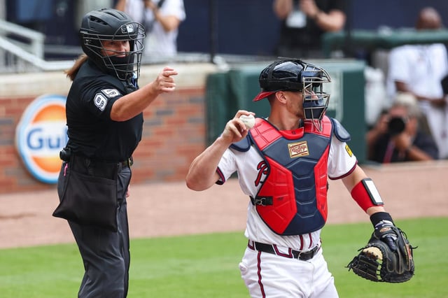 La árbitra de home, Jen Pawol, canta un strike durante la primera entrada de un juego de béisbol entre los Marlins de Miami y los Bravos de Atlanta, el domingo 10 de agosto de 2025, en Atlanta. (AP Photo/Colin Hubbard)