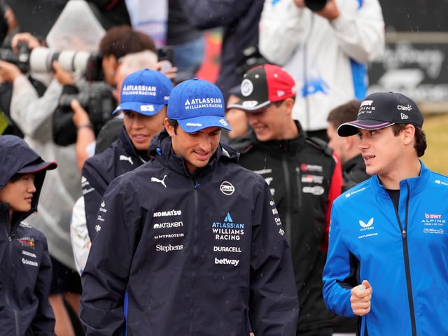 Williams driver Carlos Sainz of Spain, centre, and Alpine driver Franco Colapinto of Argentina take part in the drivers parade before the British Formula One Grand Prix race at the Silverstone racetrack in Silverstone, England, Sunday, July 6, 2025. (AP Photo/Darko Bandic)