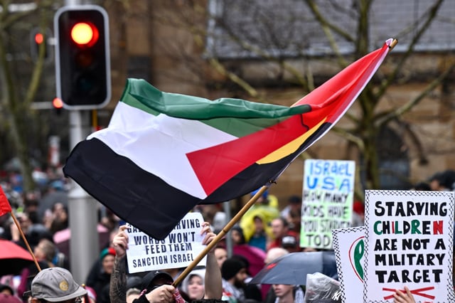 SYDNEY, AUSTRALIA - AUGUST 03: Protesters in support of Palestinians in Gaza hold flags and placards as they march towards the Sydney Harbour Bridge on August 03, 2025 in Sydney, Australia. Protesters in Sydney and Melbourne joined marches and actions globally, as pressure mounts on the Israeli government over a devastating humanitarian crisis unfolding as its war against Hamas continues. (Photo by Izhar Khan/Getty Images)