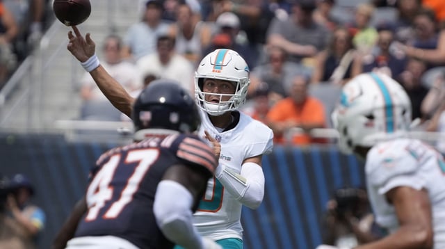 Aug 10, 2025; Chicago, Illinois, USA; Miami Dolphins quarterback Zach Wilson (0) passes the ball over Chicago Bears linebacker Ruben Hyppolite II (47) during the first half at Soldier Field. Mandatory Credit: David Banks-Imagn Images