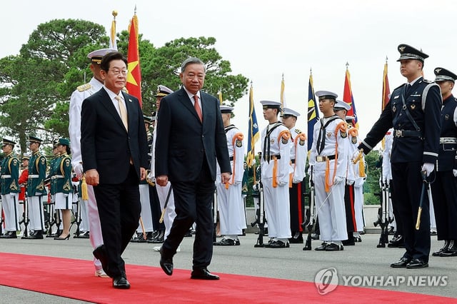 President Lee Jae Myung (L) and To Lam, secretary general of Vietnam's Communist Party, review an honor guard during a welcoming ceremony at the presidential office in Seoul on Aug. 11, 2025. (Pool photo) (Yonhap)