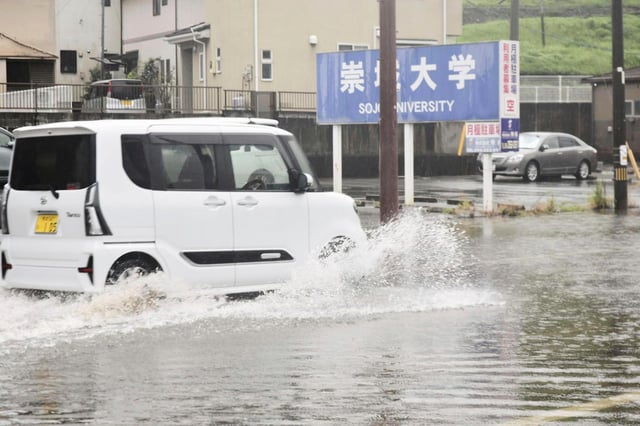 Un vehículo avanza en un camino inundado el lunes 11 de agosto de 2025, en Kumamoto, en el sur de Japón. (Kyodo News vía AP)