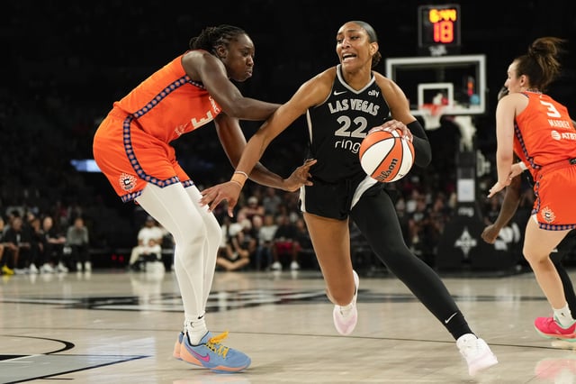 Aug 10, 2025; Las Vegas, Nevada, USA; Las Vegas Aces center A'ja Wilson (22) drives to the basket against Connecticut Sun center Tina Charles (31) during the second half of a WNBA basketball game at Michelob Ultra Arena. Mandatory Credit: Lucas Peltier-Imagn Images