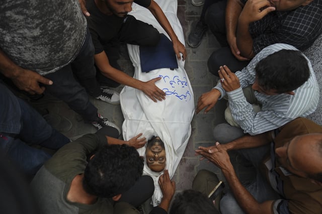 Colleagues and friends mourn over the body Al Jazeera correspondent Mohamed Qureiqa who was killed with his colleague Anas al-Sharif and other journalists by an Israeli airstrike, at Shifa Hospital in Gaza City Monday, Aug. 11, 2025. (AP Photo/Jehad Alshrafi)
