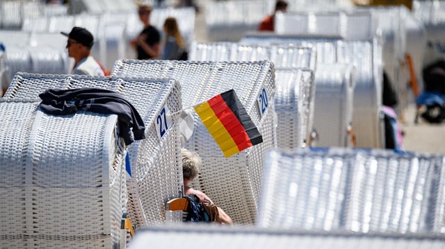 Eine Deutschland-Fahne hängt an einem Strandkorb am Ostsee-Strand.