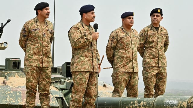 Chief of Army Staff of Pakistan Asim Munir holds a microphone during his visit at the Tilla Field Firing Ranges (TFFR) to witness the Exercise Hammer Strike, a high-intensity field training exercise conducted by the Pakistan Army's Mangla Strike Corps, in Mangla, Pakistan.