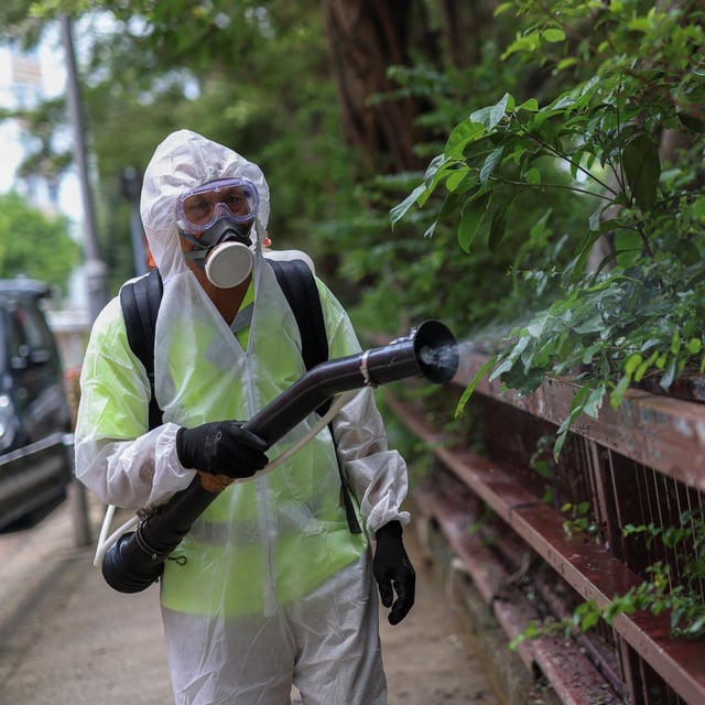 A worker sprays insecticide at a public housing estate following reports of imported cases of Chikungunya in Hong Kong, China, August 7, 2025. REUTERS/Tyrone Siu