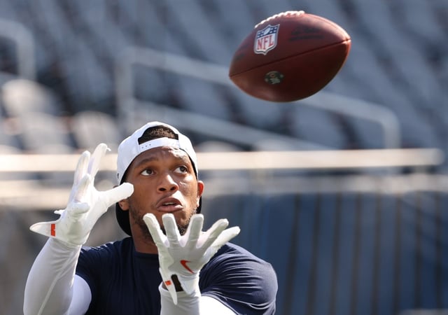 Bears wide receiver DJ Moore catches a pass thrown by Caleb Williams before the start of a game against the Dolphins at Soldier Field on Aug. 10, 2025. (Stacey Wescott/Chicago Tribune)