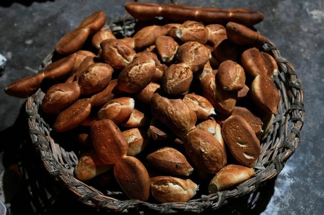 Pan recién horneado llamado &#34;pan de batalla&#34;, elaborado con harina subsidiada por el gobierno, en una canasta en una panadería de El Alto, Bolivia, el viernes 8 de agosto de 2025. (AP Foto/Juan Karita)