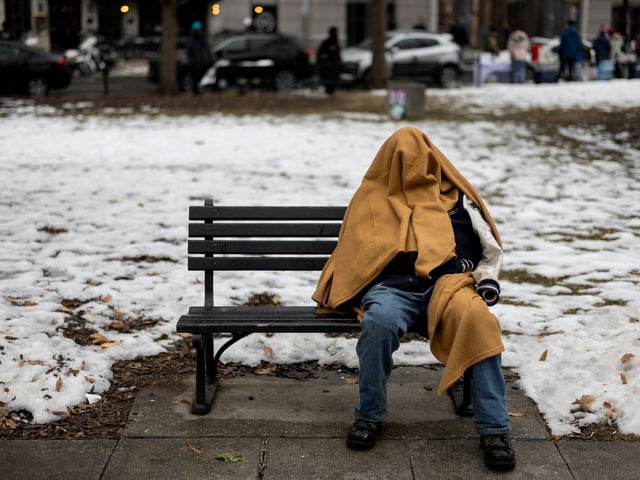 FILE PHOTO: A homeless person sits on a bench in a park, ahead of the presidential inauguration of U.S. President-elect Donald Trump, in Washington, U.S., January 18, 2025. REUTERS/Marko Djurica/File Photo