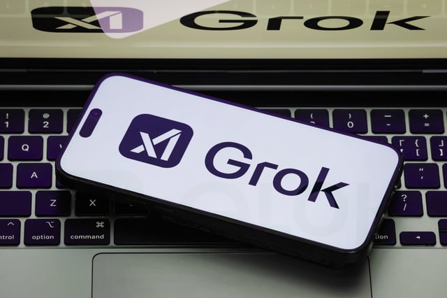 Stock Image: A close-up of a smartphone displaying the Grok app, featuring the app&#39;s logo on a white screen, with the same Grok logo shown on a laptop screen on February 19, 2025 in Chongqing, China.