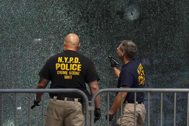 Members of NYPD Crime Unit examine a door with bullet holes at the scene of Monday's deadly shooting, Tuesday, July 29, 2025, in New York. (AP Photo/Yuki Iwamura)