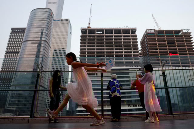 People visit a terrace of a shopping mall overlooking the central business district (CBD), in Beijing, China August 11, 2025. REUTERS/Tingshu Wang