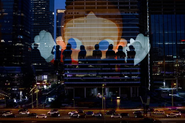 The reflection of silhouettes of people is visible on a glass on a terrace of a shopping mall overlooking Beijing's central business district (CBD), China , August 11, 2025. REUTERS/Tingshu Wang
