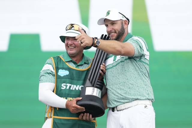 BOLINGBROOK, ILLINOIS - AUGUST 10: Dean Burmester of Stinger GC (R) holds the individual trophy and celebrates with his caddie Jason Reynolds on stage on day three of LIV Golf Chicago at Bolingbrook Golf Club on August 10, 2025 in Bolingbrook, Illinois. (Photo by Patrick McDermott/Getty Images)